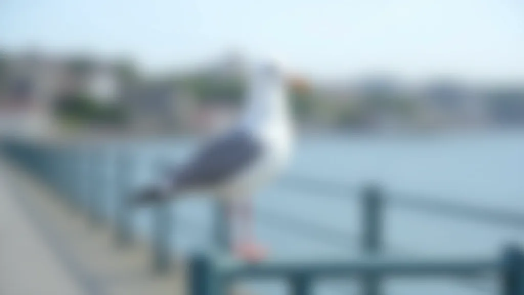 Seagull perched on railing with coastal landscape in background